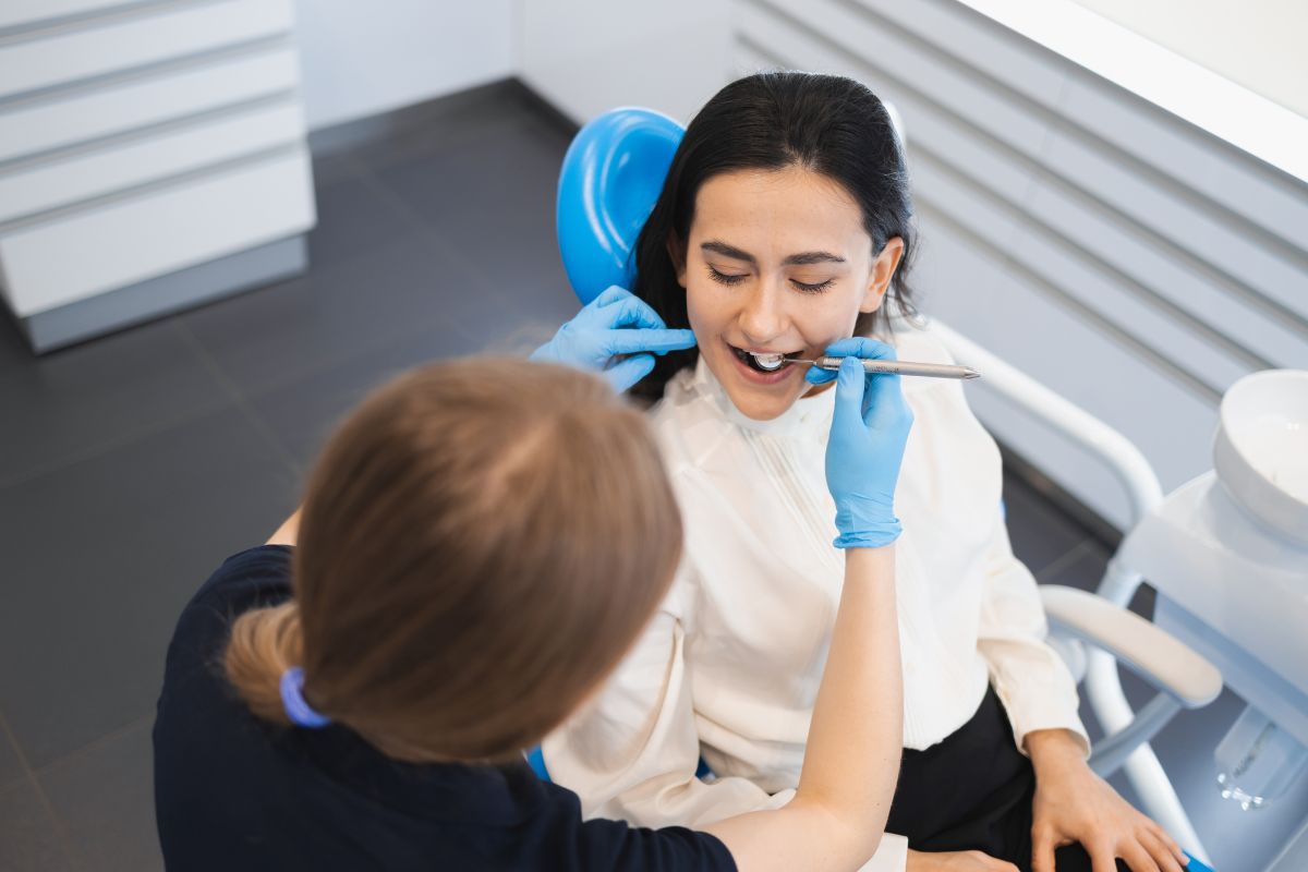 A dental professional examines a patient’s teeth during a checkup, highlighting the importance of early cavity detection and professional treatment.