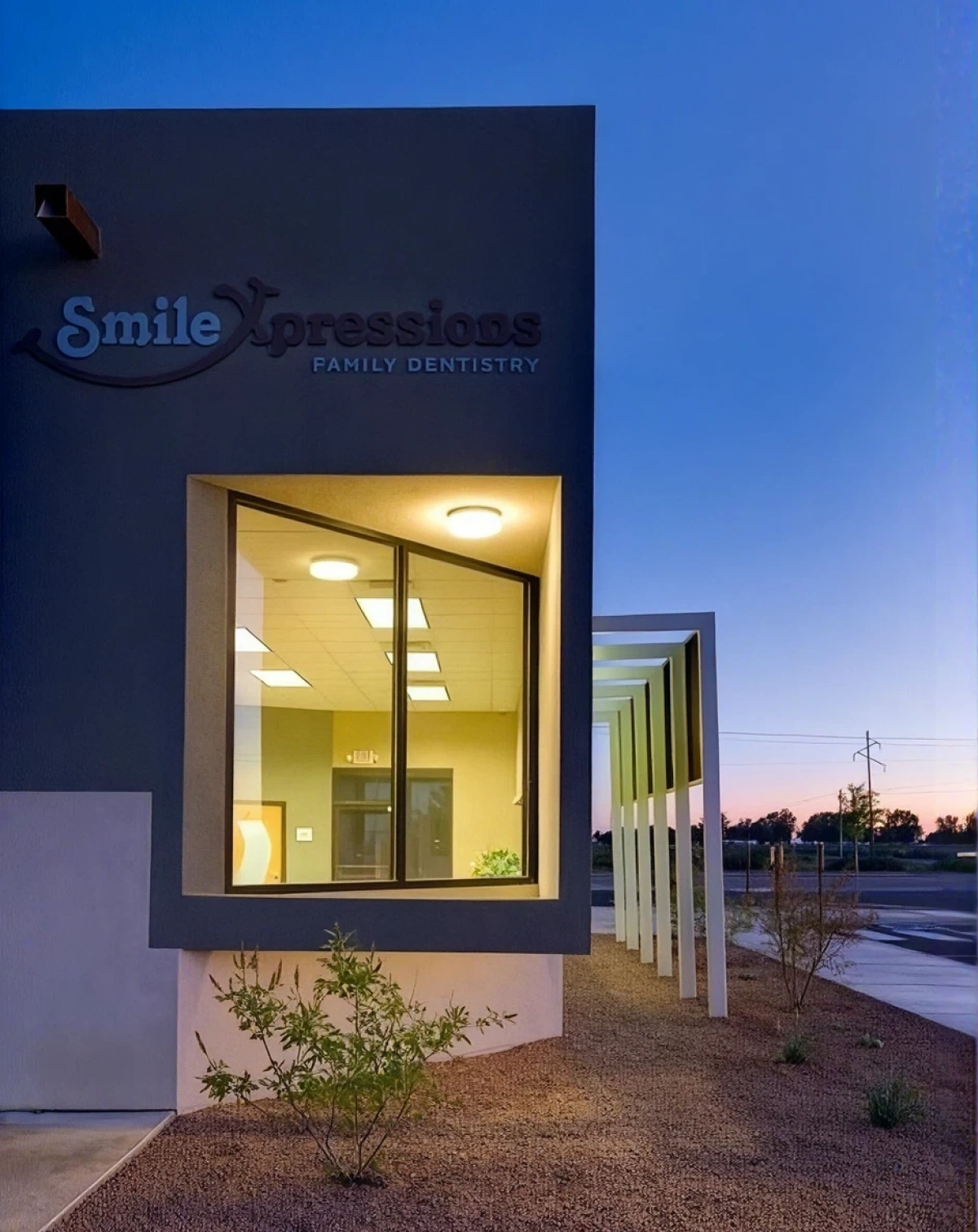 Smile Xpressions Family Dentistry building sign lit at dusk with front window