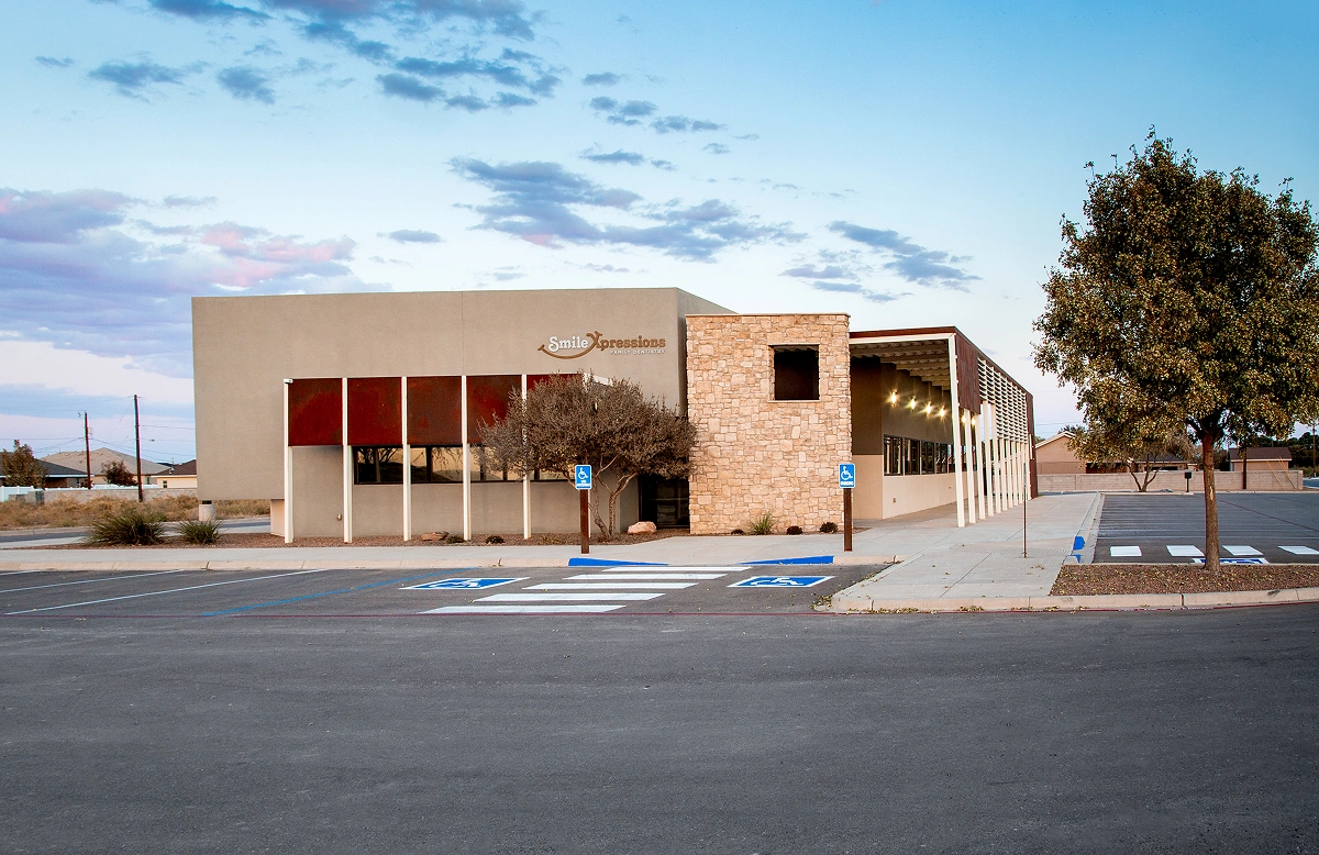 Smile Xpressions Family Dentistry building exterior with accessible parking at dusk