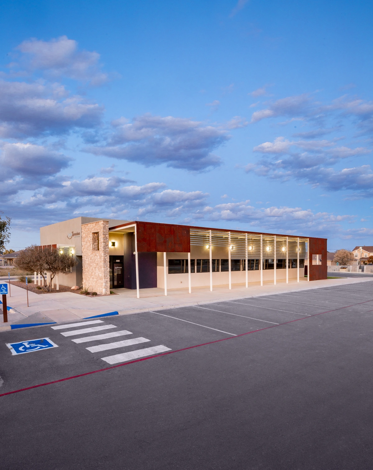 Exterior view of Smile Xpressions office building at dusk with parking lot