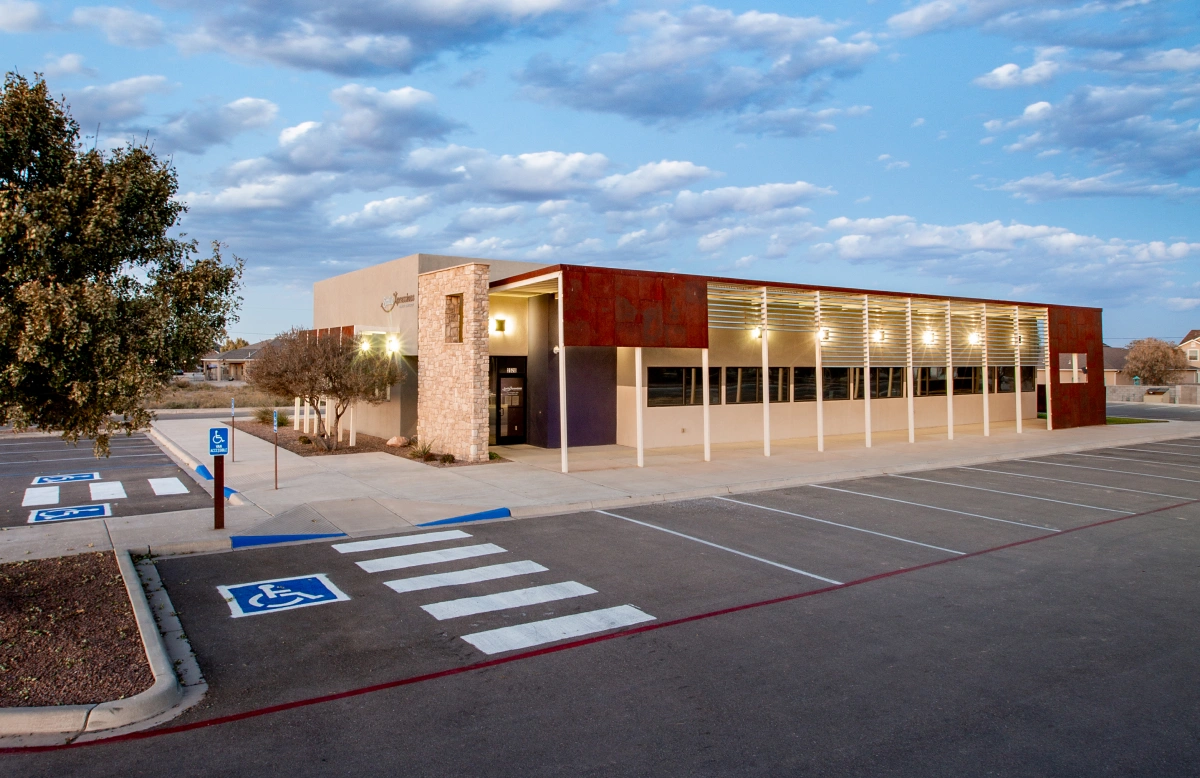 Smile Xpressions office building exterior with accessible parking at dusk