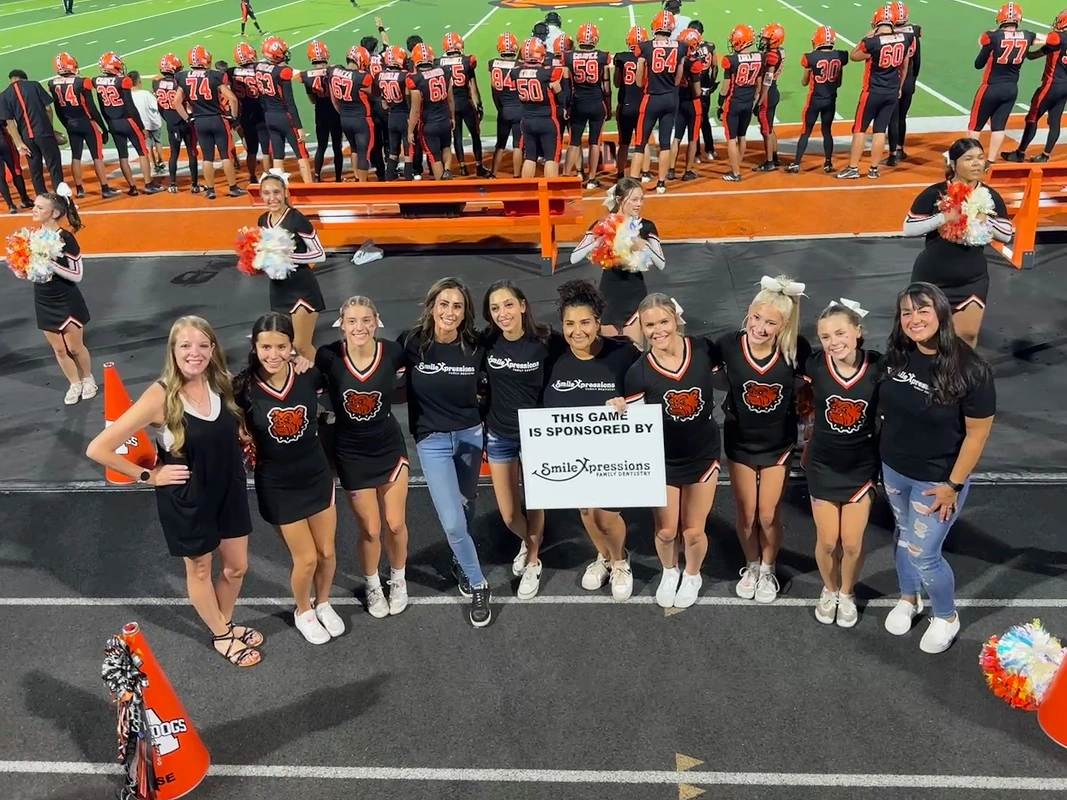Smile Xpressions Dentistry team sponsoring a local football game with the cheer squad