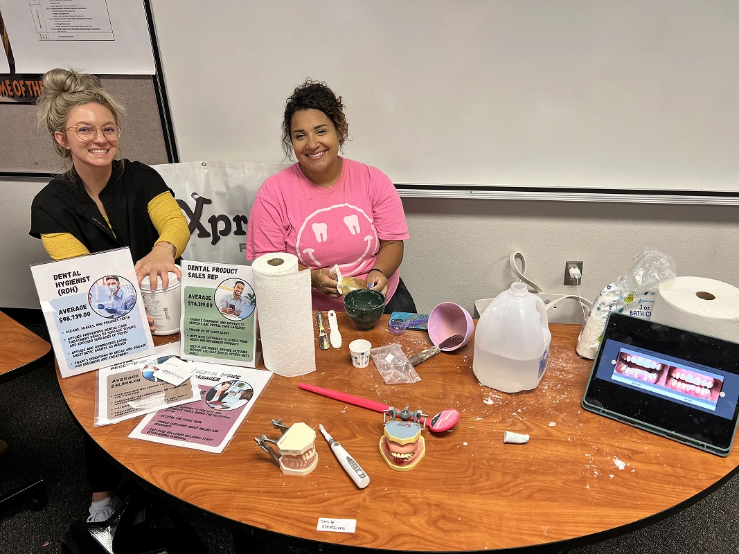 Smile Xpressions Dentistry team members at a career day promotional table