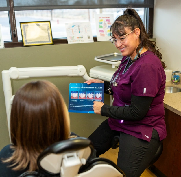 Dentist explaining oral health chart to patient at Smile Xpressions Dentistry in Artesia, NM