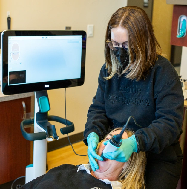 Dental hygienist performing digital scan on patient at Smile Xpressions Dentistry in Artesia, NM